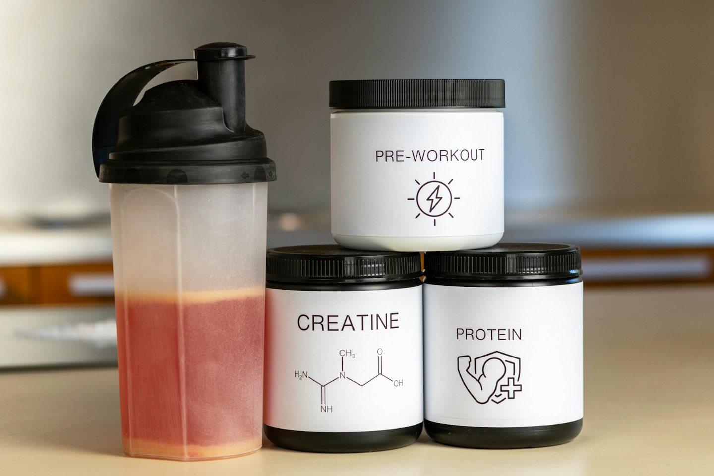Fitnesspräparate und Shaker-Flasche auf einer Theke.