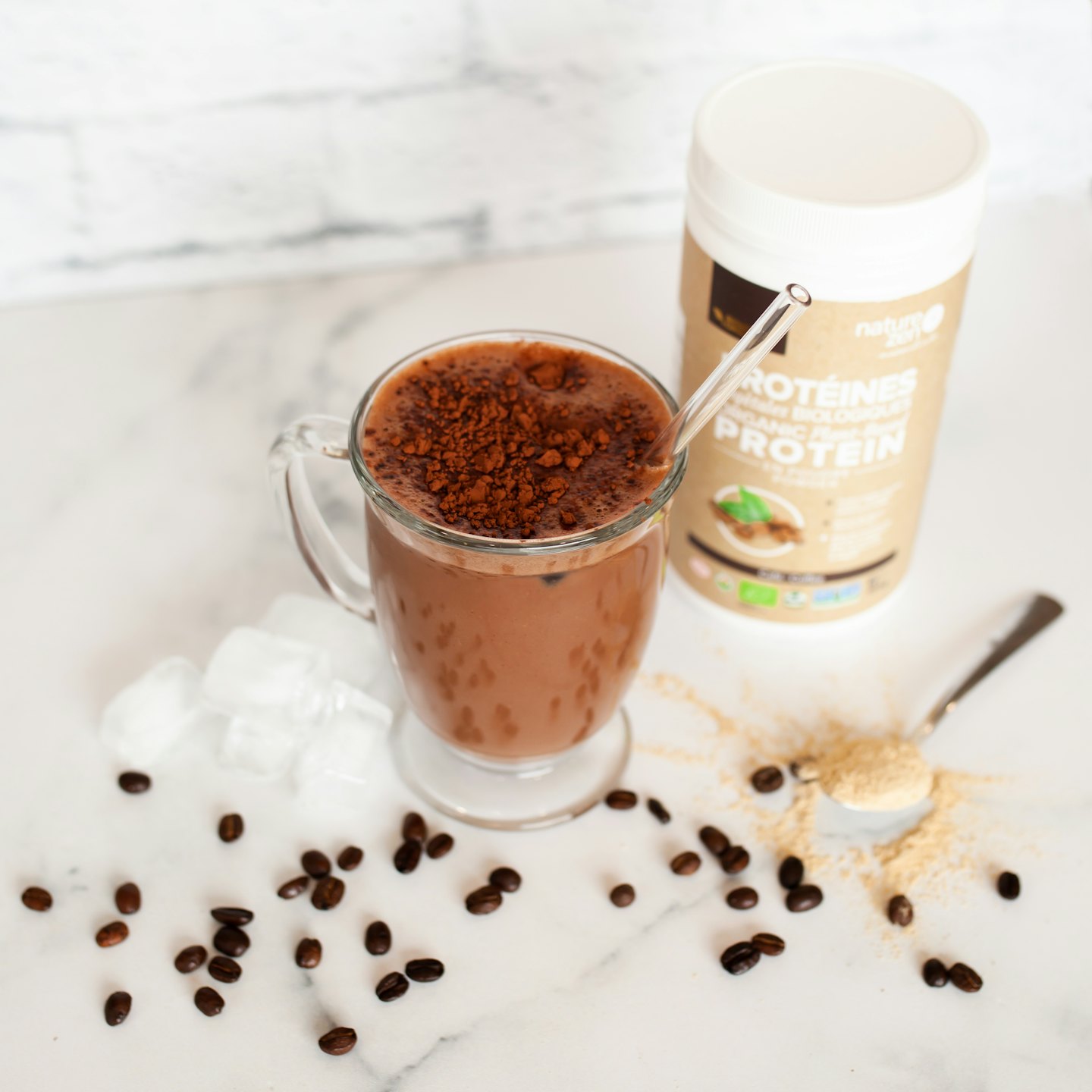Schokoladen-Proteinshake mit Kakaopulver und Kaffeebohnen.